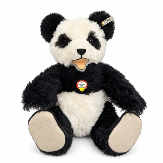 Das ist ein Panda von Steiff. Großer Panda mit zottigem, mittellangem, leicht glänzendem Fell. Schwarz sind Ohren, Augenflecken, Arme, Beine und Schultern, weiß sind Gesichtsmitte, Bauch und Brust; Pfotenballen und Sohlen sind beige. Die Schnauze ist weiß mit kleiner schwarzer Dreiecksnase und kurzer schwarzer Naht darunter. Dunkelbraune Augen sitzen in den schwarzen Flecken, der Mund ist offen und zeigt eine beige Zunge. Er sitzt und wirkt sanft, etwas überrascht.