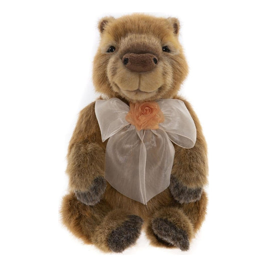 Das ist Peru, ein Capybara von Charlie Bears. Er sitzt und hat mittellanges, leicht zotteliges Fell in Braun und Beige mit dunkelgrauen Akzenten. Die runde Schnauze ist mittelbraun mit kleinen schwarzen Nasenlöchern, die schwarzen Augen sitzen in helleren Augenringen. Der Bauch ist beige und kürzer behaart, Pfoten und Pfotenballen sind dunkelgrau abgesetzt. Am Hals trägt er eine große cremefarbene Schleife mit pfirsichfarbener Blüte, sein Ausdruck wirkt ruhig.